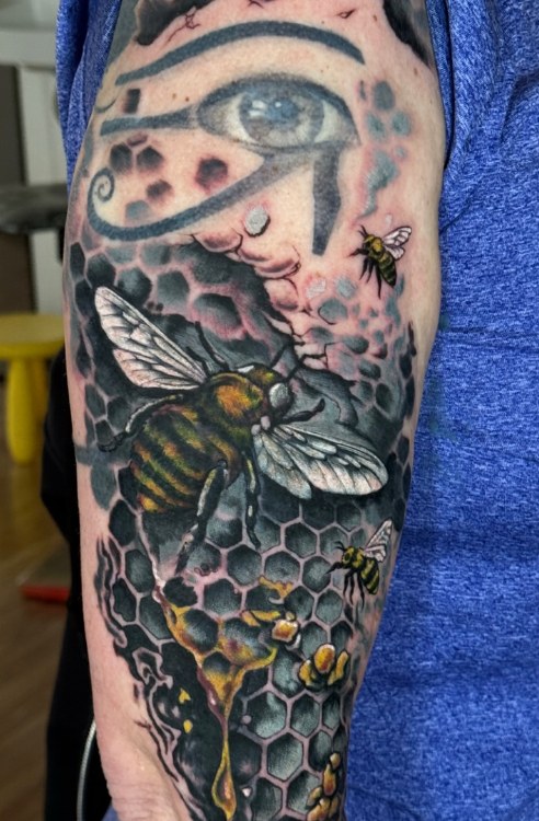 After: a bee and honeycomb cover-up tattoo by Jeremy Sramek