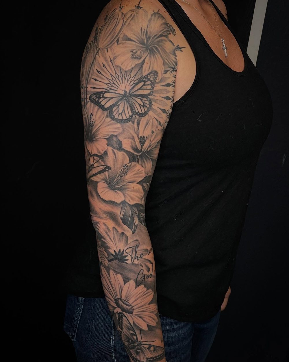 Black and grey floral sleeve tattoo with a butterfly by Jeremy Sramek