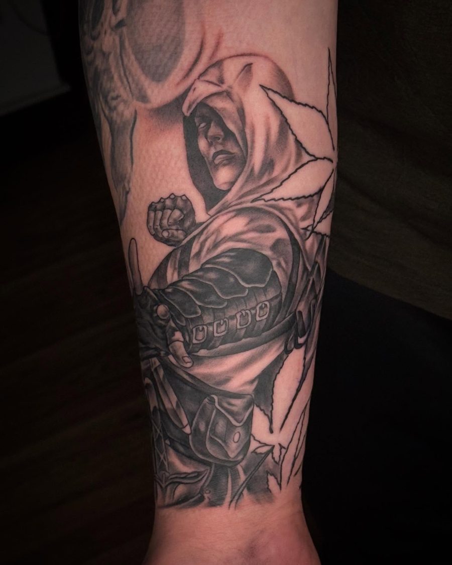 Hooded assassin forearm tattoo in black and grey by Jeremy Sramek