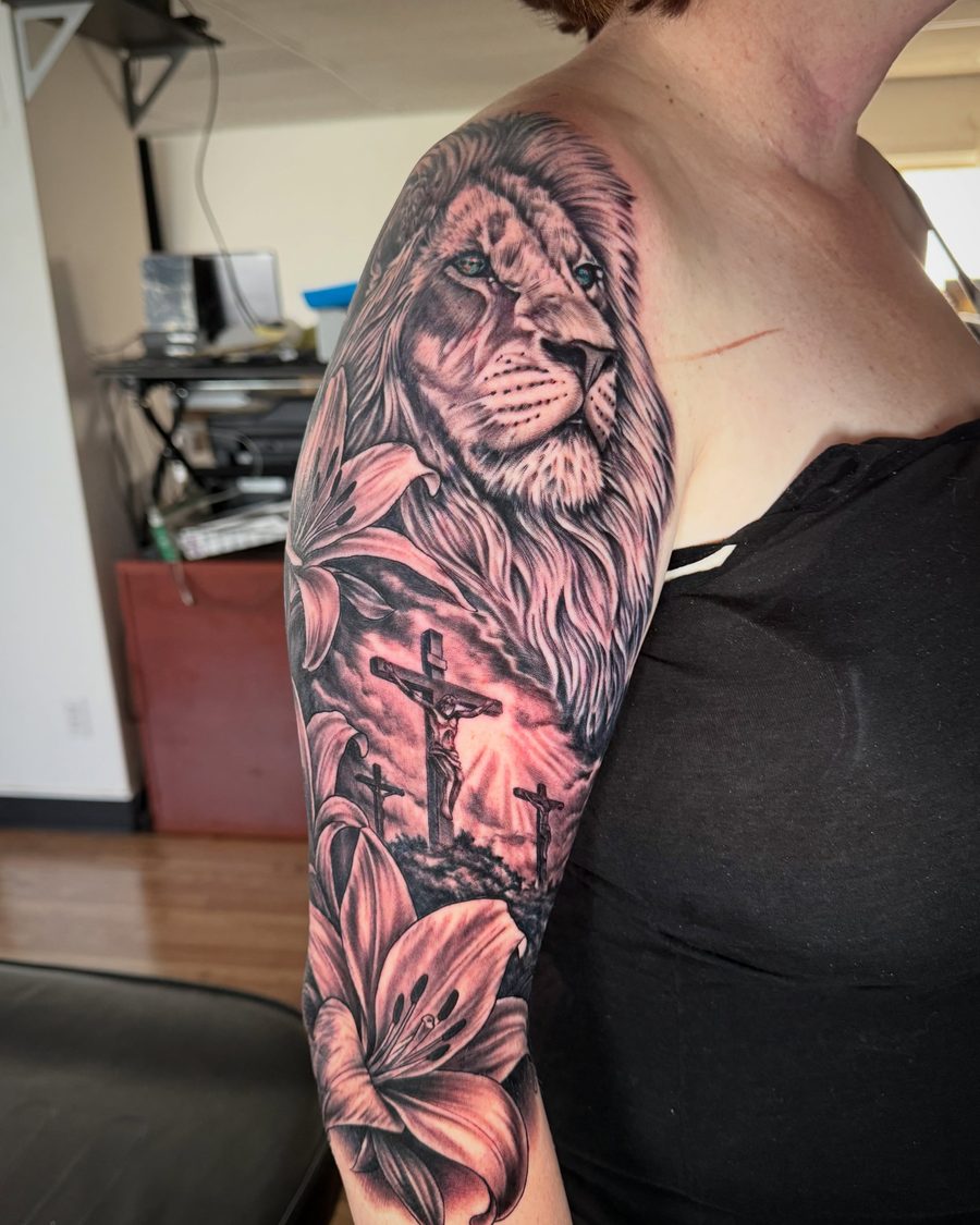 Lion, lilies and crosses half sleeve tattoo in black and grey by Jeremy Sramek