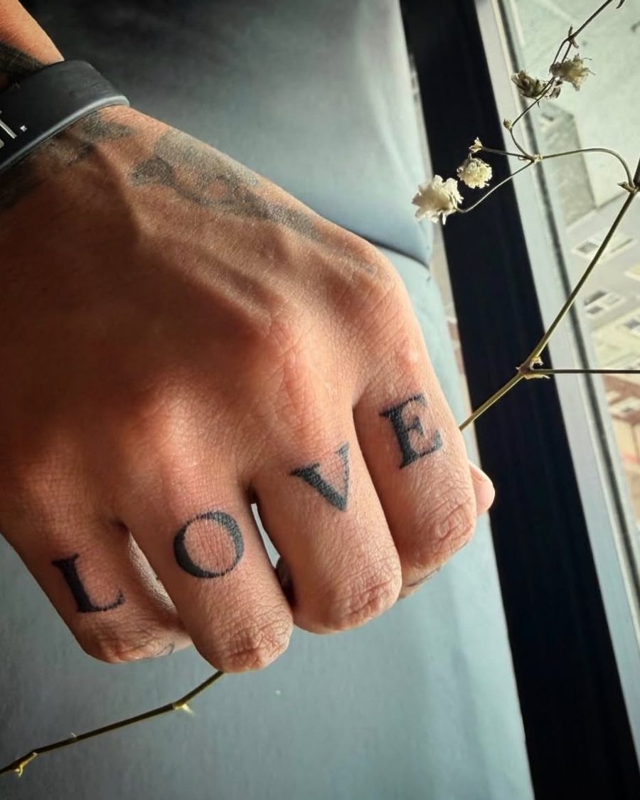LOVE lettering tattoo across the knuckles by Kain Sramek