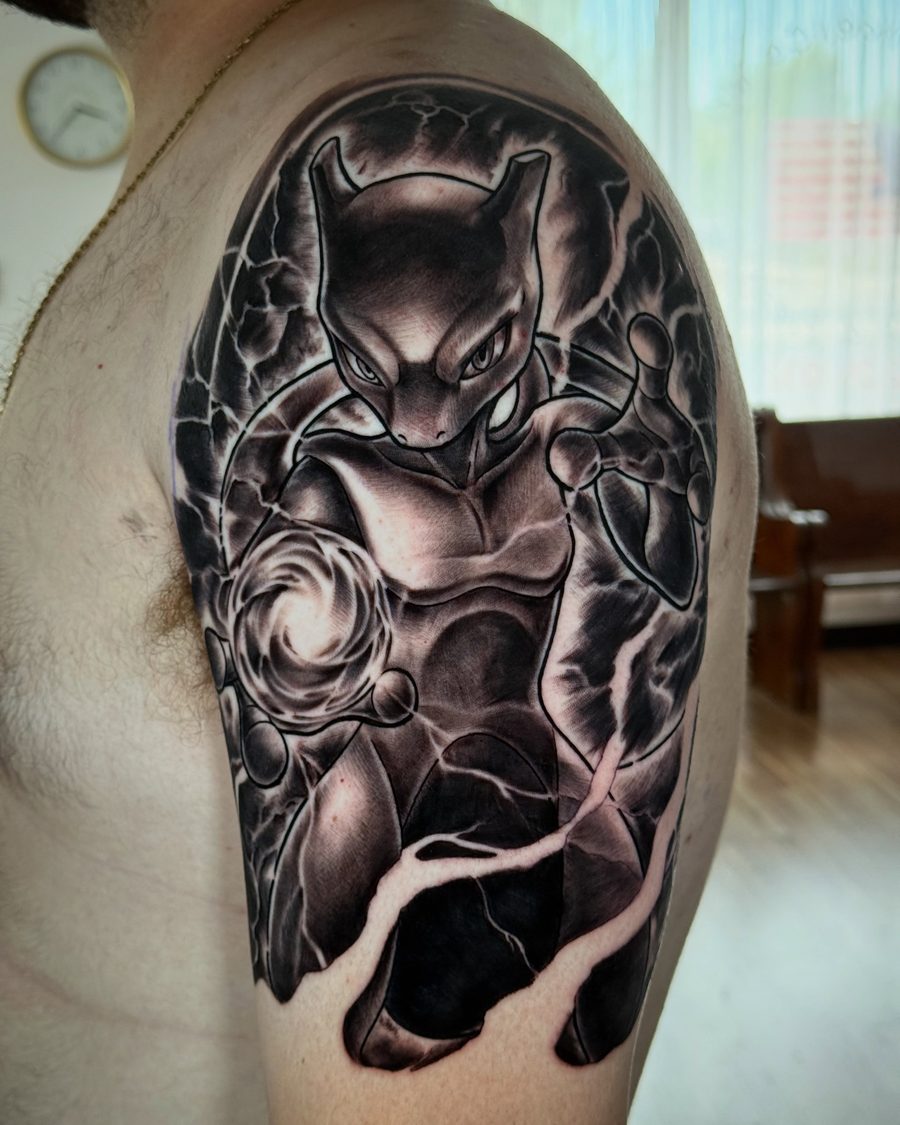 Mewtwo shoulder tattoo in black and grey by Jeremy Sramek