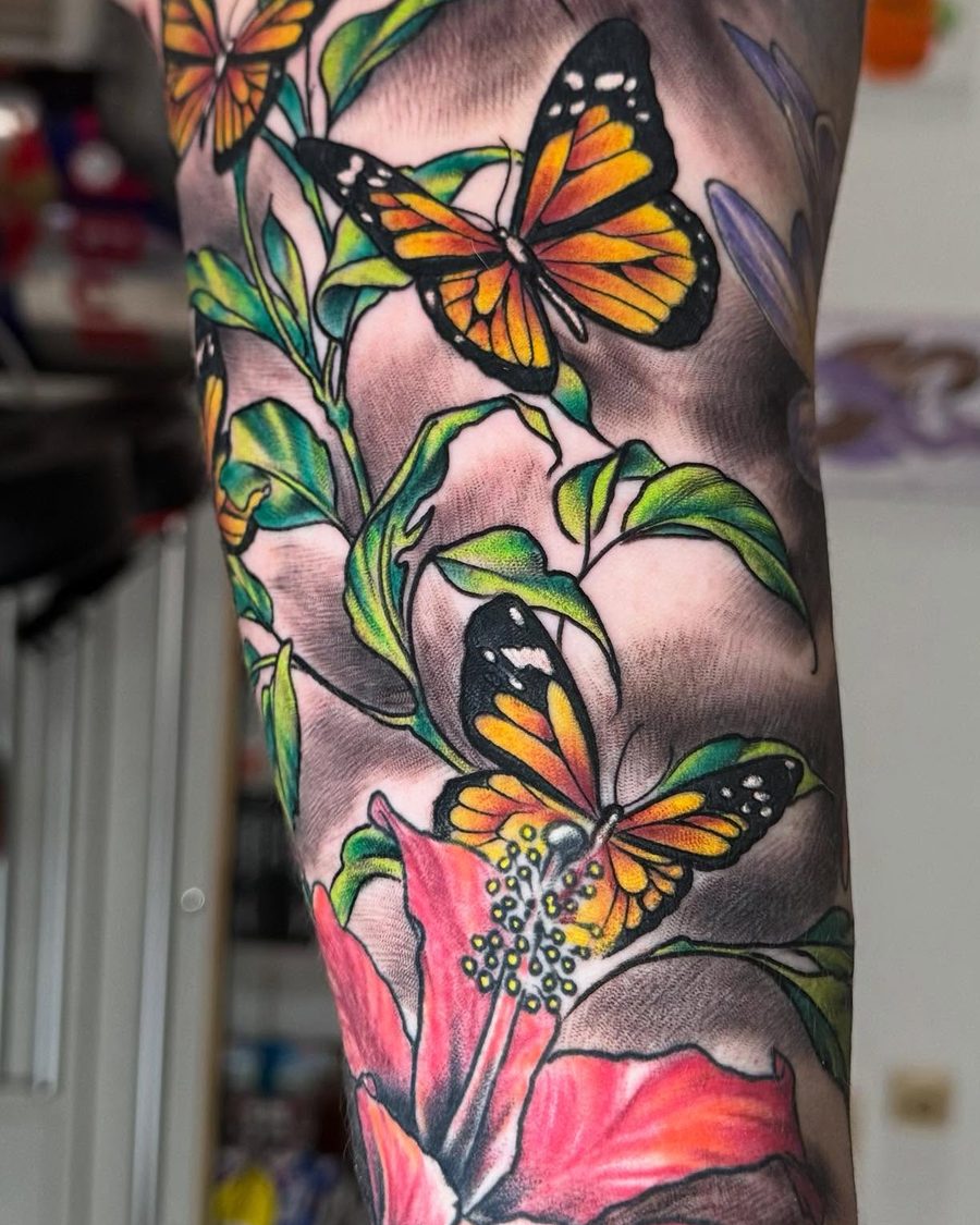 Monarch butterflies and hibiscus, a full color upper arm tattoo by Jeremy Sramek