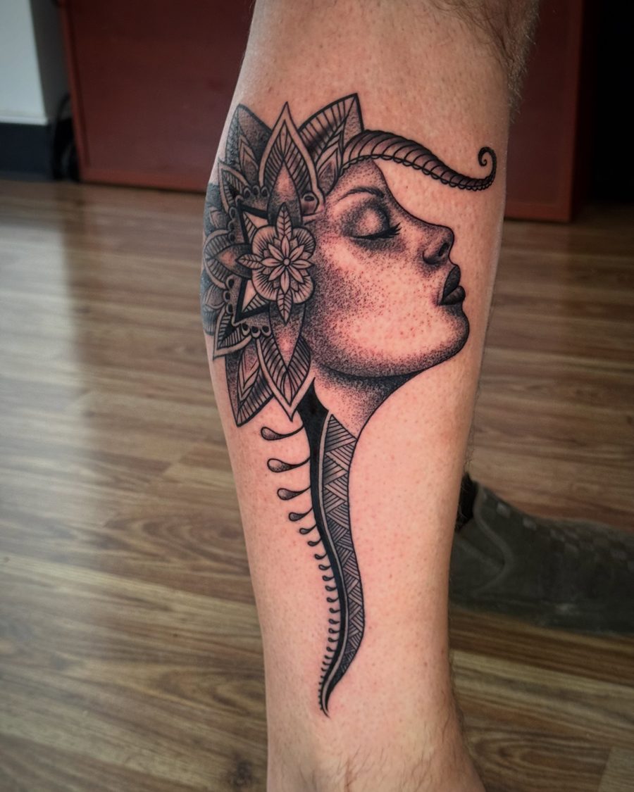 A client's own drawing made permanent: an ornamental profile tattoo on a calf by Jeremy Sramek