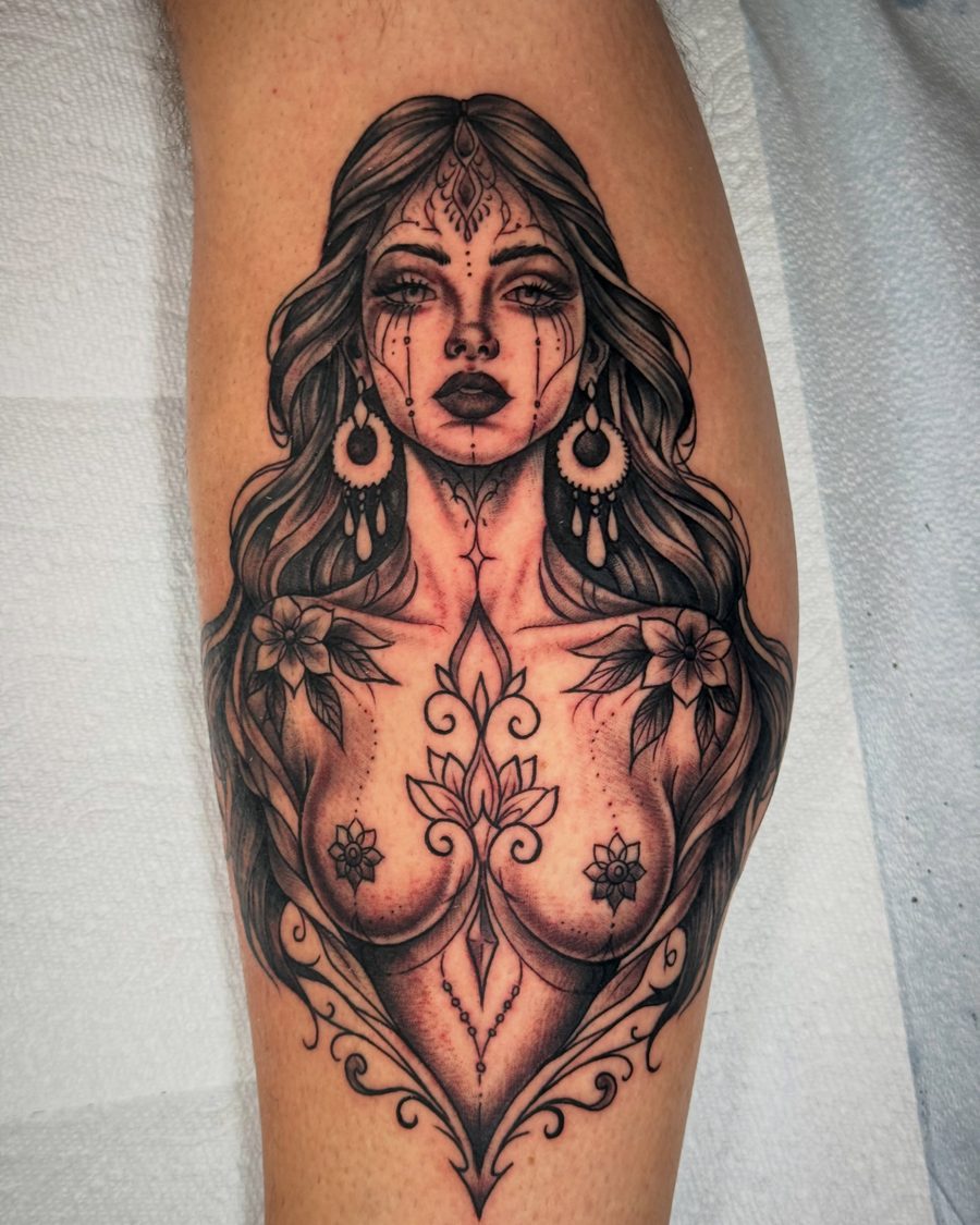 Ornamental portrait with florals, a black and grey calf tattoo by Jeremy Sramek