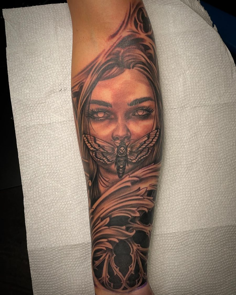Black and grey realism portrait tattoo with a moth on a forearm by Jeremy Sramek