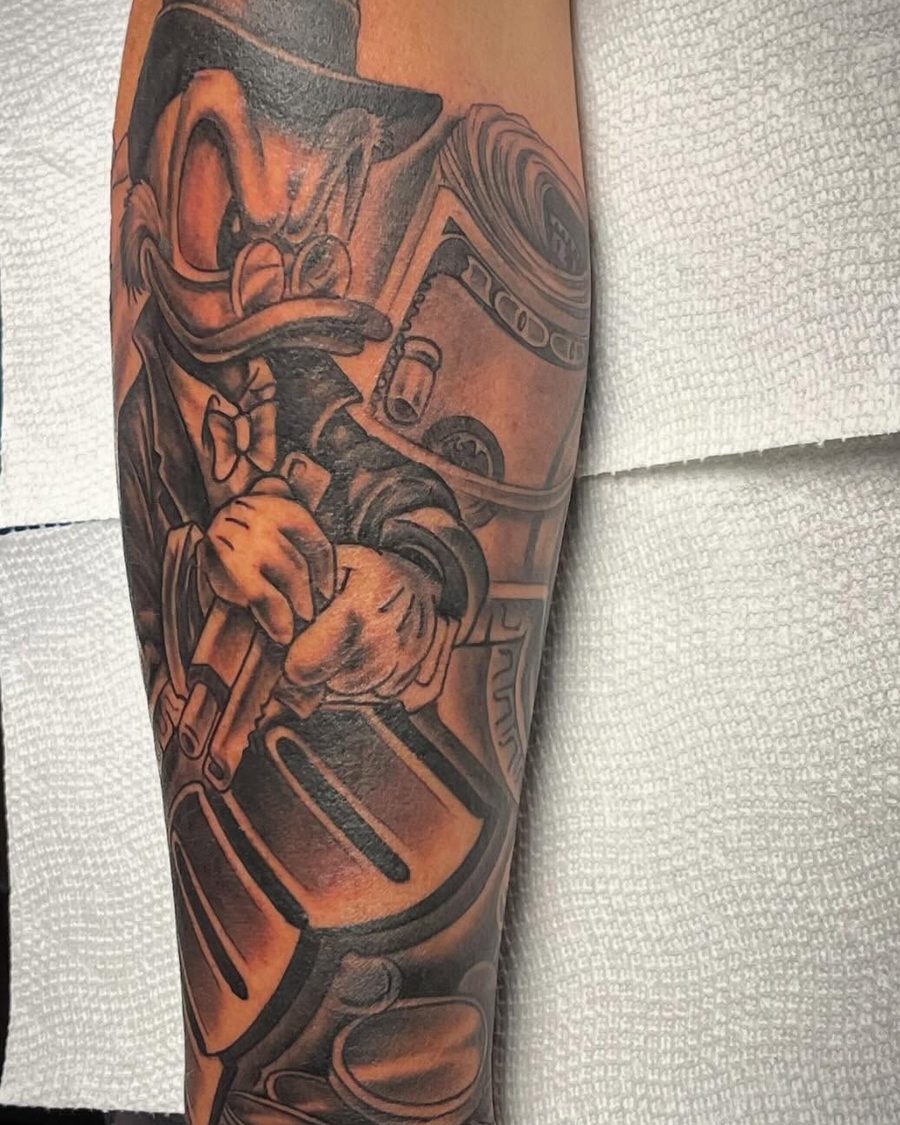 Scrooge with a gauntlet, a black and grey forearm tattoo by Jeremy Sramek