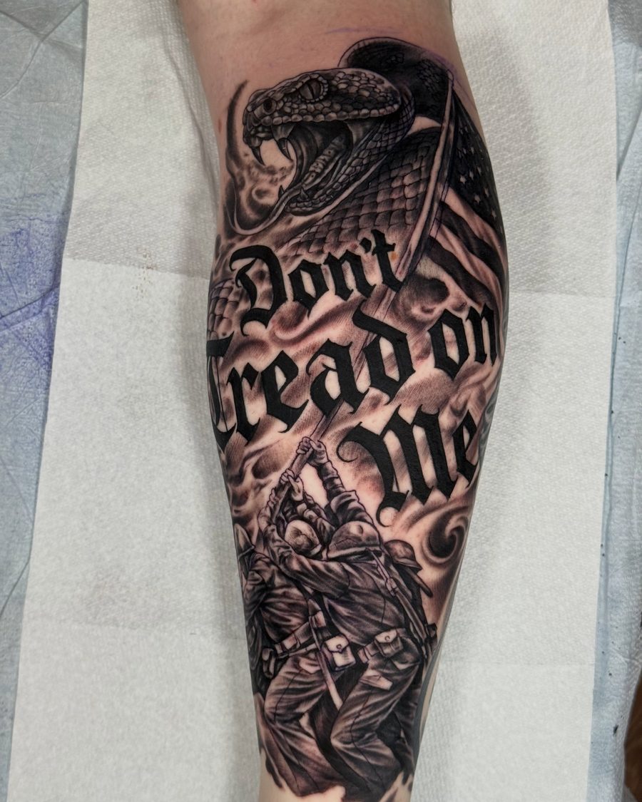 Snake with Don't Tread on Me lettering, a black and grey forearm tattoo by Jeremy Sramek
