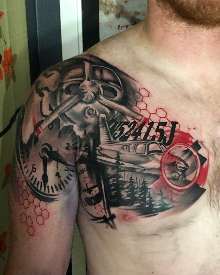Trash Polka shoulder tattoo by Jeremy Sramek: a vintage plane, a clock and pines with red accents