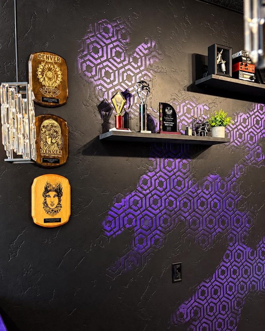 Awards on the purple honeycomb wall at Vanity Ink in Wheat Ridge