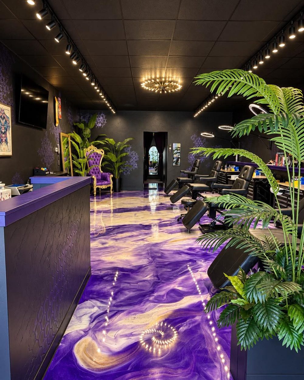 The front desk at Vanity Ink in Wheat Ridge, the purple epoxy floor running back to the workstations