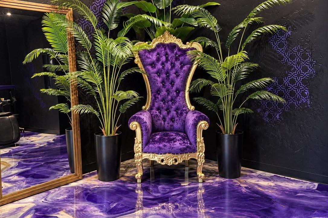 The purple throne between palms on the marble epoxy floor at Vanity Ink in Wheat Ridge